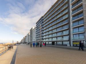 un grand bâtiment sur un trottoir à côté d'une plage dans l'établissement Romanza on floor 4, à Middelkerke