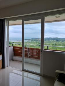 a room with a sliding glass door with a view at THE NOVE NUVASA KALANI TOWER in Nongsa
