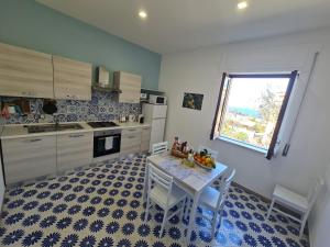 a kitchen with a table and chairs and a window at CASA BETANIA DA PEPPE in Sorrento