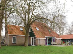 een huis met een oranje dak en een boom bij Beautiful farmhouse in the middle of nature 