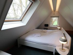 een kleine slaapkamer met een bed op zolder bij Beautiful farmhouse in the middle of nature 