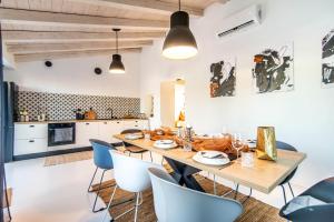 a kitchen and dining room with a wooden table and chairs at Villa Gravisi by Villa Plus in Orbanići