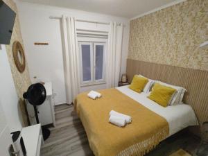 una camera da letto con un letto grande con cuscini gialli di Costa Paradise Beach a Costa da Caparica