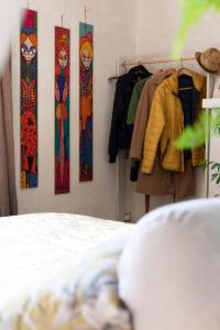 Botanica في كالكاتا: غرفة نوم مع سرير وملابس معلقة على رف