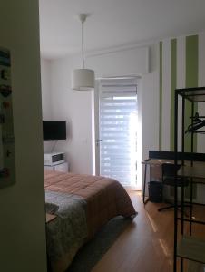 a bedroom with a bed and a desk and a window at Stanza indipendente a Gallarate in Gallarate