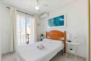 a white bedroom with a bed and a window at HE Paola 2 in Orihuela Costa +28 photos