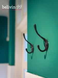 a pair of antlers hanging on a green wall at Belivin99 Residence in Bangkok