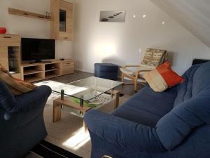 uma sala de estar com um sofá azul e uma mesa de vidro em Holiday apartment Weipert em Ehrenberg