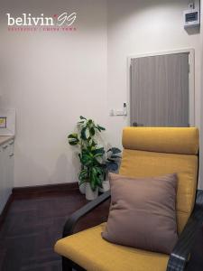 Belivin99 Residence في بانكوك: غرفة انتظار فيها كرسي اصفر ومصنع