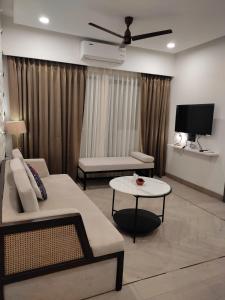 ein Wohnzimmer mit einem Sofa und einem Tisch in der Unterkunft Goan Fiesta Ultra Luxury CALANGUTE in Calangute