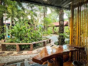 eine Terrasse mit Bänken, einem Tisch und Bäumen in der Unterkunft Pang Long Chao resort in Trang