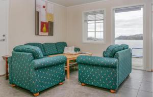 een woonkamer met 2 stoelen en een tafel bij Stunning Home In Sjernary With Kitchen in Sjernarøy