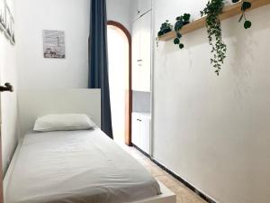 ラスパルマス・デ・グランカナリアにあるPuerto Canteras III by Canary365のベッドと窓が備わる小さな客室です。