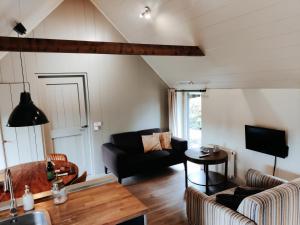 een woonkamer met een bank en een tafel bij Gastenverblijf Lheederhof in Dwingeloo