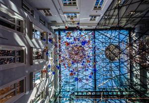 een glazen plafond met een kroonluchter in een gebouw bij Hotel Indigo Warsaw Nowy Świat, an IHG Hotel in Warschau