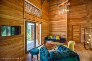 a living room with wooden walls and a blue couch at LE VILLAGE D'HÉLÈNE - Natura Resort in Ouidah