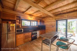 a kitchen with a table and chairs in a cabin at LE VILLAGE D'HÉLÈNE - Natura Resort in Ouidah