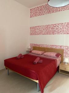 Un dormitorio con una gran cama roja con sábanas rojas en Casa Vacanze Villa Annamaria, en Scanzano Jonico