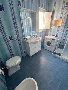 a bathroom with a toilet sink and a washing machine at Casa Vacanze Villa Annamaria in Scanzano
