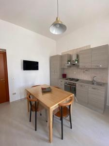 cocina con mesa de madera y 2 sillas en Casa Vacanze Villa Annamaria, en Scanzano Jonico