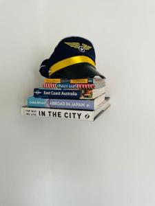 a stack of books with a hat on top of them at Unique London Heathrow Airport cabin, gated free parking, and courtyard in New Bedfont
