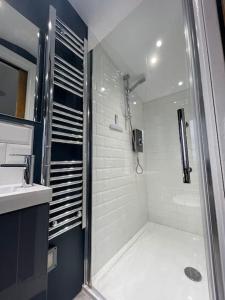 a bathroom with a shower and a sink at Unique London Heathrow Airport cabin, gated free parking, and courtyard in New Bedfont