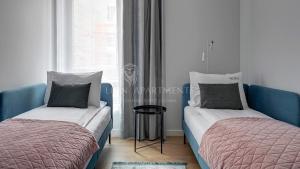dwa łóżka siedzące obok okna w pokoju w obiekcie Lion Apartments - SCALA City Center Mustang&Parking w Gdańsku