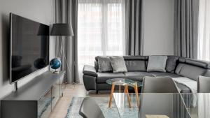 a living room with a couch and a glass table at Lion Apartments - SCALA City Center Mustang&Parking in Gdańsk