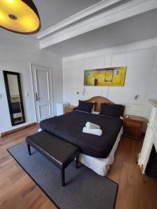 a bedroom with a large bed with a black blanket at Hotel Santiago Patio Bellavista in Santiago