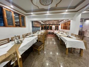 a dining room with long tables and wooden chairs at Ashina Eco Resort in Kargil