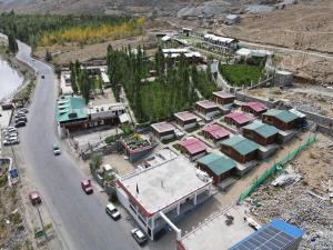 eine Luftansicht eines Gebäudes mit Autos auf einer Straße in der Unterkunft Ashina Eco Resort in Kargil