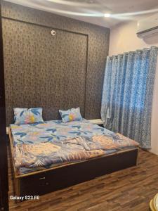a bedroom with a bed with blue sheets and a window at Tirupati home stay in Ujjain +11 photos