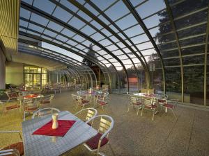 una cafetería con mesas y sillas y techo de cristal en EA Rodinné chatky Kraskov, en Kraskov