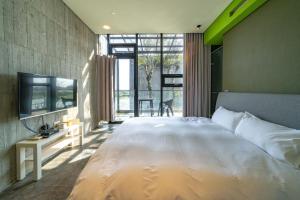 een slaapkamer met een groot wit bed en een tv bij 陸月Villa 宜蘭包棟民宿 l 寵物友善 l 烤肉 l KTV in Dongshan +8 foto's
