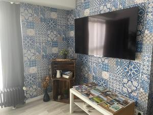 Habitación con paredes de azulejos azules y TV en la pared. en FeWo “ruhige Momente” in Waldkirch en Waldkirch