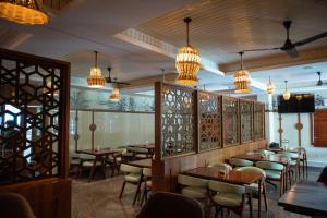 a dining room with tables and chairs and chandeliers at PVR Suites off Bannerghatta Road in Bangalore