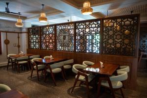 a restaurant with tables and chairs and stained glass windows at PVR Suites off Bannerghatta Road in Bangalore