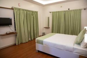 a bedroom with a bed and a flat screen tv at PVR Suites off Bannerghatta Road in Bangalore
