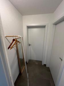 pasillo con puerta, espejo y armario en Kleine Ferienwohnung - Nähe Schweizergrenze, en Hohentengen