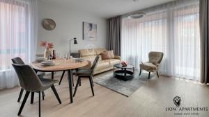 a living room with a table and a couch at Lion Apartments - SCALA City Center Apartments&Parking H in Gdańsk