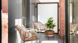- un ensemble de chaises et d'une table sur une terrasse dans l'établissement Lion Apartments - SCALA City Center Apartments&Parking H, à Gdańsk