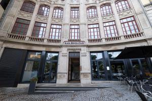 um grande edifício com janelas, mesas e cadeiras em Axis Porto Club Aliados em Porto