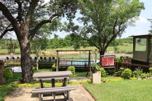 un parque con mesa de picnic y parque infantil en Sabie River Bush Lodge en Hazyview