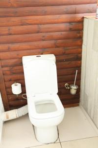 a toilet in a bathroom with a wooden wall at Sabie River Bush Lodge in Hazyview