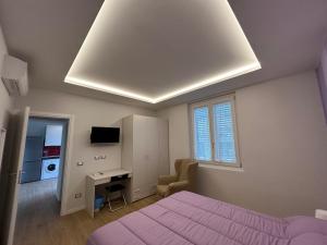 - une chambre avec un lit violet et un bureau dans l'établissement Etrusco Viola - Appartamento "Giglio Viola", à Bagno a Ripoli