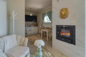 a living room with a fireplace and a couch and a table at Bungalow Lux 2 in Novi Banovci