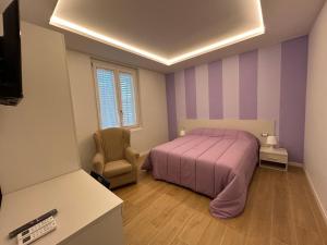 1 dormitorio con 1 cama de color púrpura y 1 silla en Etrusco Viola - Appartamento "Giglio Viola" en Bagno a Ripoli