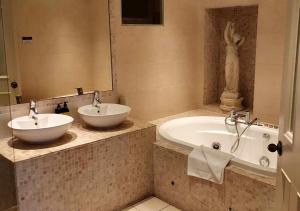 uma casa de banho com 2 lavatórios e uma banheira em Headfort Arms Hotel em Kells
