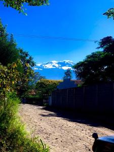 un camino de tierra con montañas cubiertas de nieve en la distancia en Ukali ukalini homes en Sanya Juu