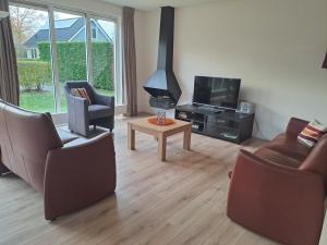 a living room with two chairs and a television at Vakantiepark Bosmeer Friesland in Noordwolde
